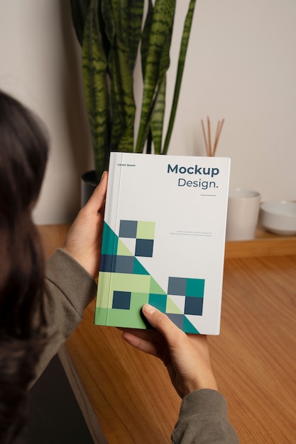 person holding and reading a book at home