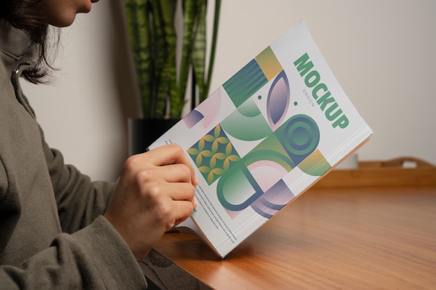 person holding and reading a book at home