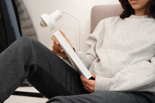 PSD person holding and reading a book at home