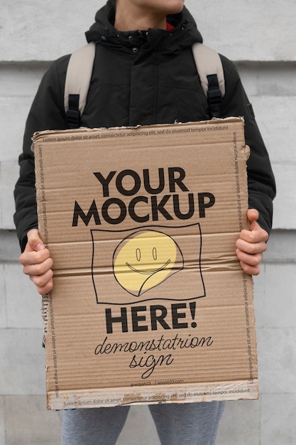 Person holding sign at protest with mock-up message