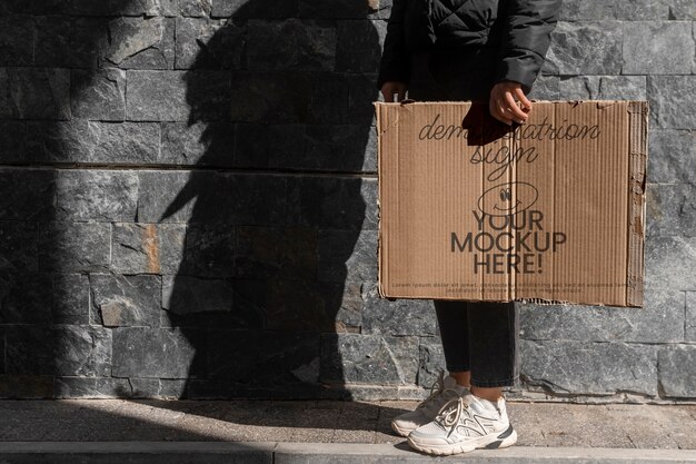 Person holding sign at protest with mock-up message