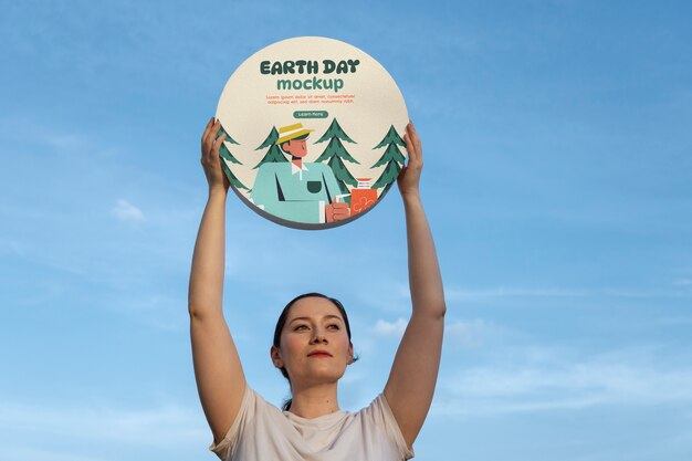 Person holding a signboard mockup for earth day