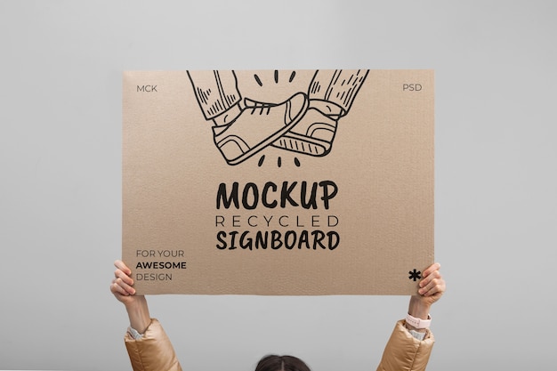 Person holding signboard with drawing from recycled paper