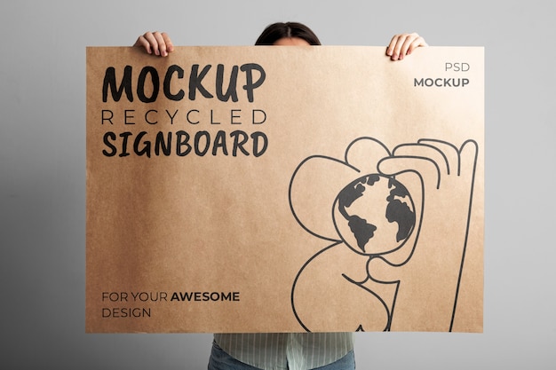 Person holding signboard with drawing from recycled paper