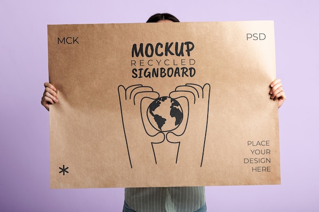 Person holding signboard with drawing from recycled paper