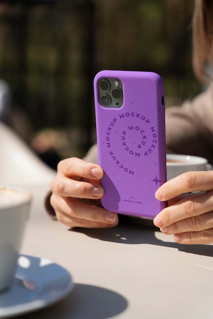 Person holding smartphone mock-up outdoors