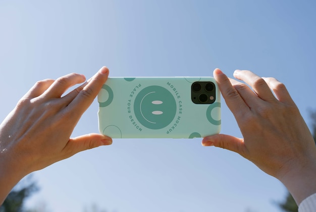 Person holding smartphone mock-up outdoors