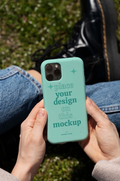 PSD person holding smartphone mock-up outdoors