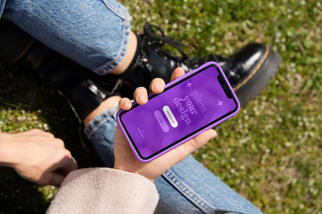 PSD person holding smartphone mock-up outdoors