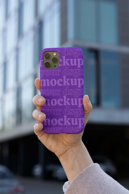 Person holding smartphone mock-up outdoors