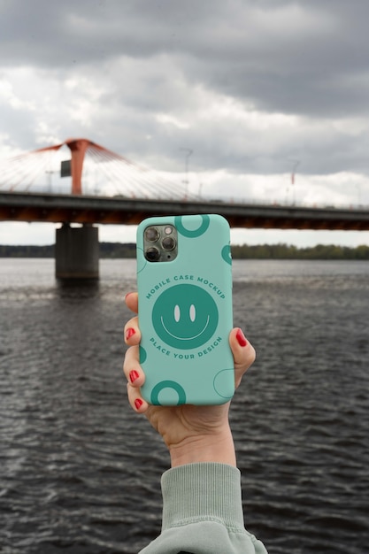 Person holding smartphone mock-up outdoors