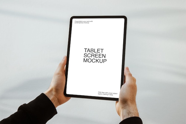 a person holding a tablet with screen mockup