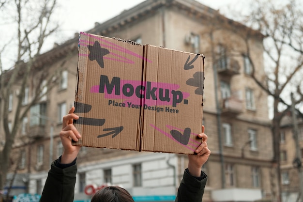 Person holding up a sign mockup