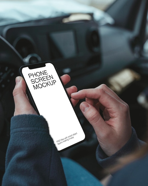 A person is holding a phone with screen mockup on the car