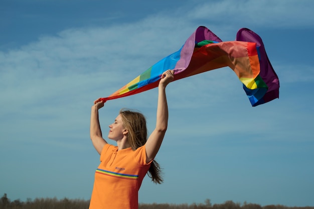 Человек на открытом воздухе с радужным флагом гордости