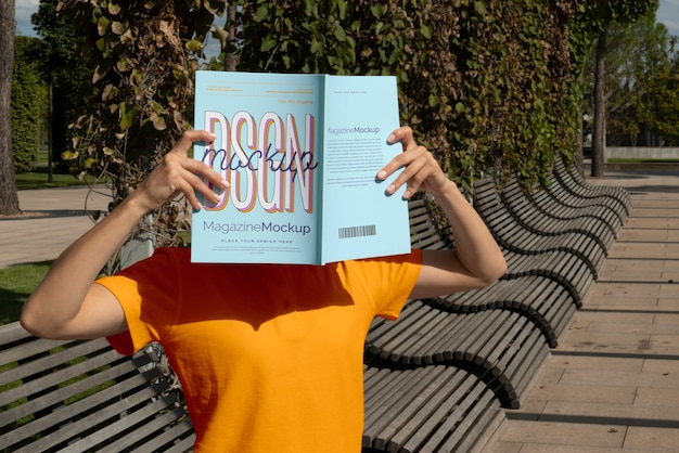 PSD person reading color pop magazine with cover mockup