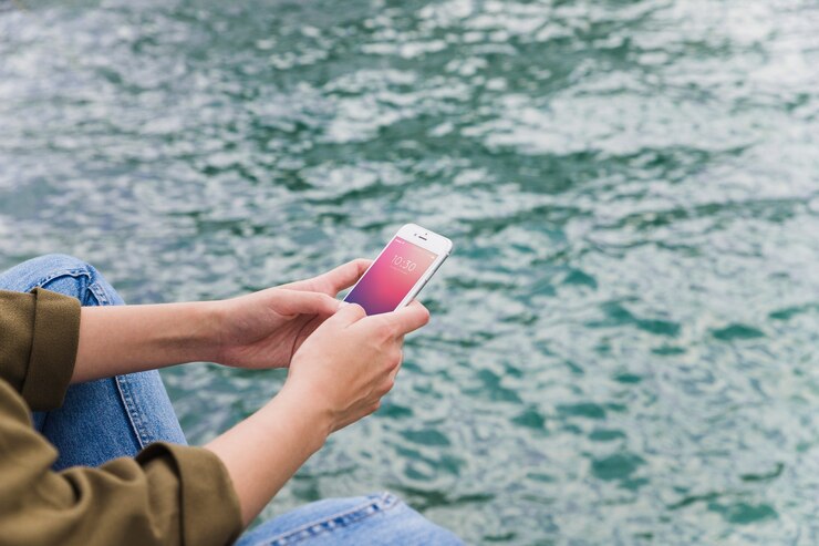 PSD person using smartphone mockup on sea background