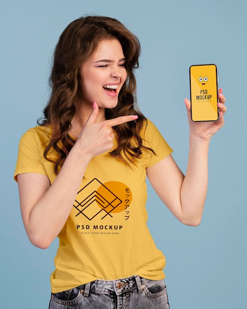 Person with excited expression pointing to phone mockup