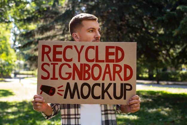 PSD person with a recycled signboard mockup