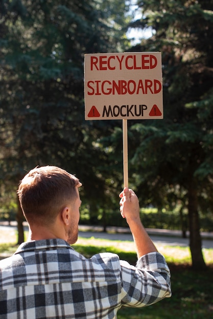 PSD person with a recycled signboard mockup