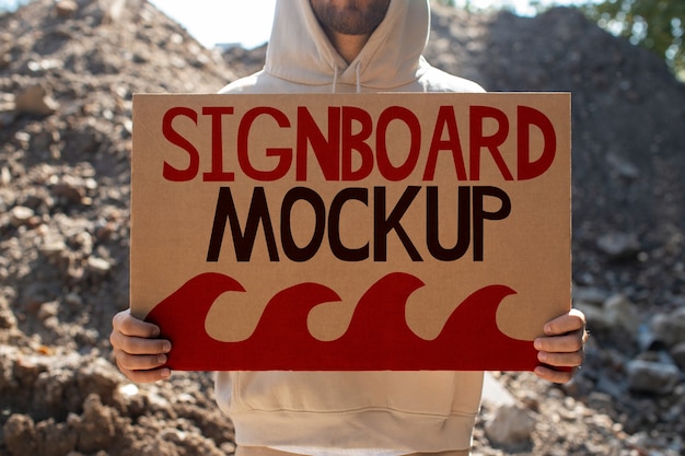 Person with a recycled signboard mockup