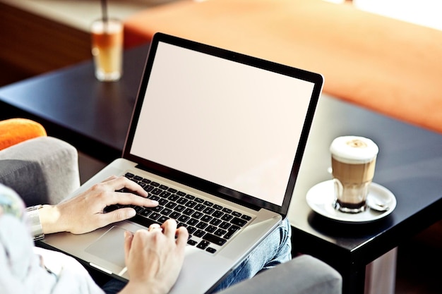 Persoon die aan een laptop werkt in een café