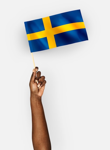 Persoon die de vlag van het koninkrijk zweden zwaaien