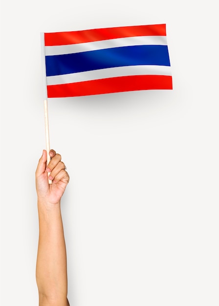 Persoon die de vlag van Koninkrijk van Thailand golft