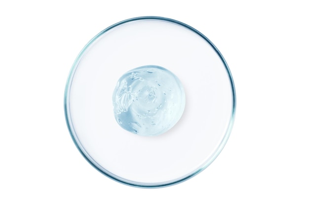 Petri dish with a drop and a smear of a transparent gel or serum on an empty background