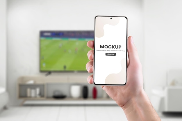 phone mockup in hand with soccer game on tv in background