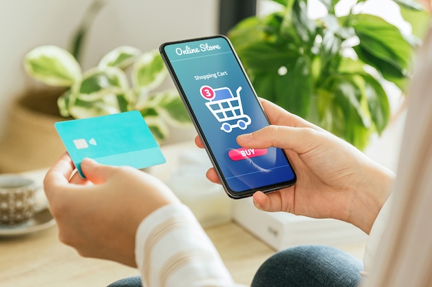 Phone mockup held by a woman paying an order online from home