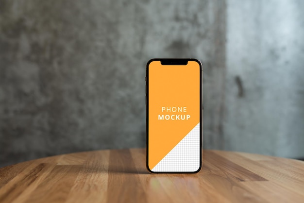 PSD コンクリートの背景を持つ木製のテーブルの電話のモックアップ