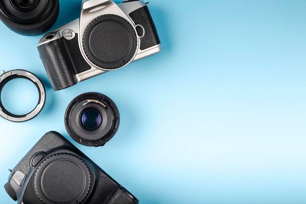 Photo camera lenses and photographers equipment on a blue background with space for text