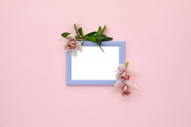 Photo frame decorated with green leaves and orchid flowers