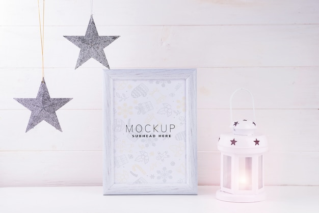 Photo mock up with white frame, stars and lantern on white wooden background