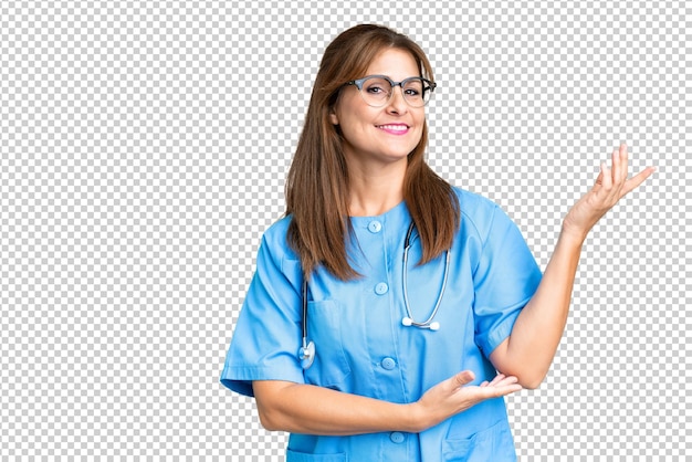 PSD pielęgniarka w średnim wieku na izolowanym tle wyciąga ręce na bok, zapraszając do przybycia