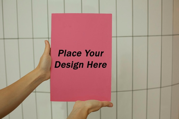 pink paper held by woman mockup psd