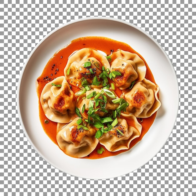 Plate of dumplings with green onions and a red sauce on transparent background