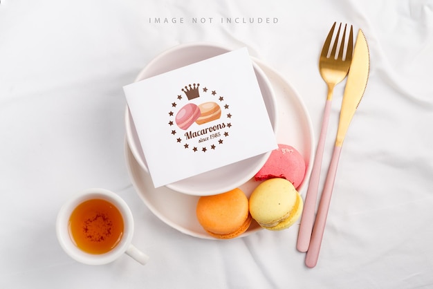 Piatto con carta mockup in bianco e macarons su sfondo tessile