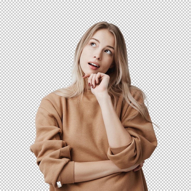 PSD portrait of pensive fairhaired dreamy hipster woman imagines something in her mind looks upwards being deep in thoughts touching chin attractive young blonde female dreams about weekends