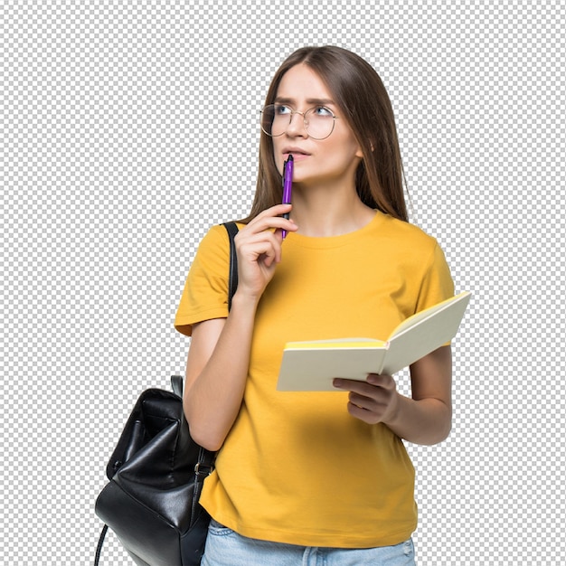 portrait of a smiling casual girl student with backpack writing in a notepad while standing with books isolated over white wall