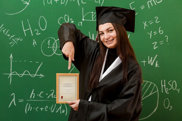 PSD portrait of student pointing at diploma