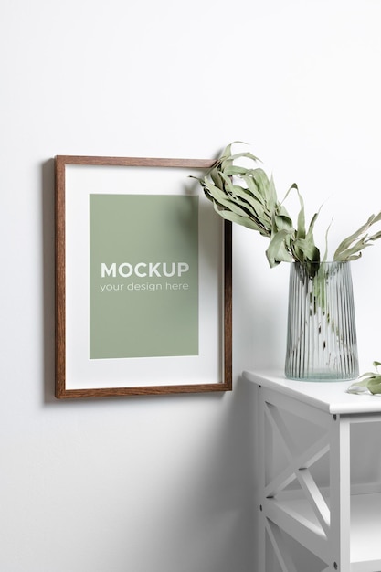 PSD portrait wooden frame mockup on white wall with fresh eucalyptus in vase