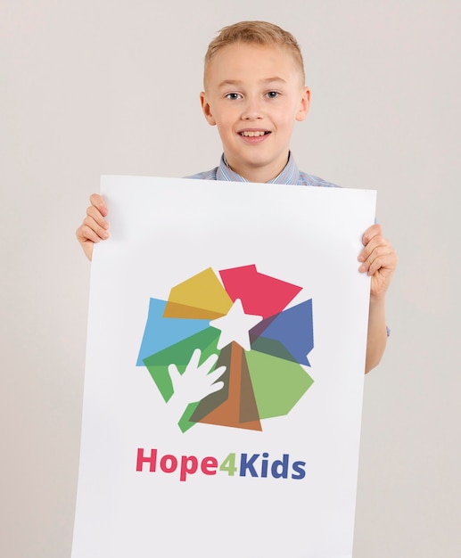 Portrait of young boy holding mock-up sign