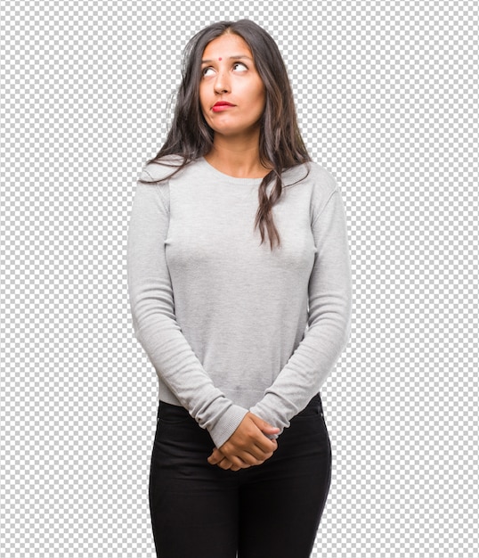 PSD portrait of young indian woman doubting and confused, thinking of an idea or worried about something