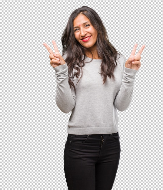 portrait of young indian woman fun and happy, positive and natural, doing a gesture of victory, peace concept