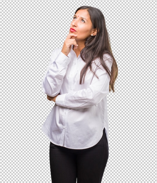 Portret van een jonge Indiase vrouw denken en opzoeken, verward over een idee, zou proberen een oplossing te vinden