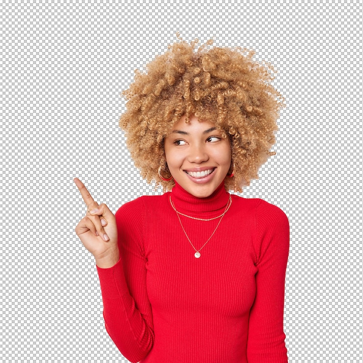 PSD positive curly haired woman points finger on left side shows blank space for your advertising content wears casual red turtleneck isolated over white background place your company title here