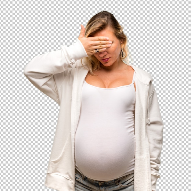 Pregnant blonde woman with white sweatshirt covering eyes by hands