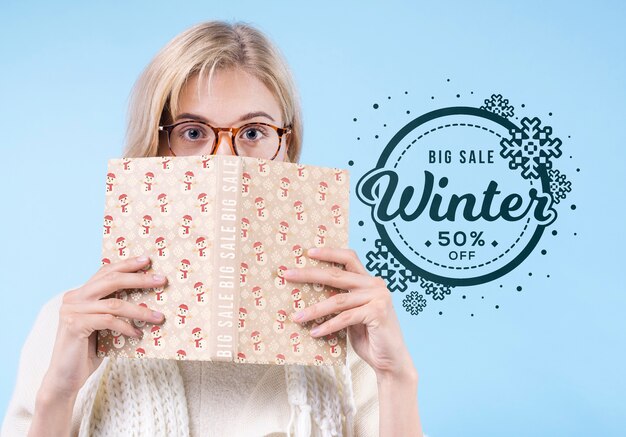 Pretty young girl covering face with book